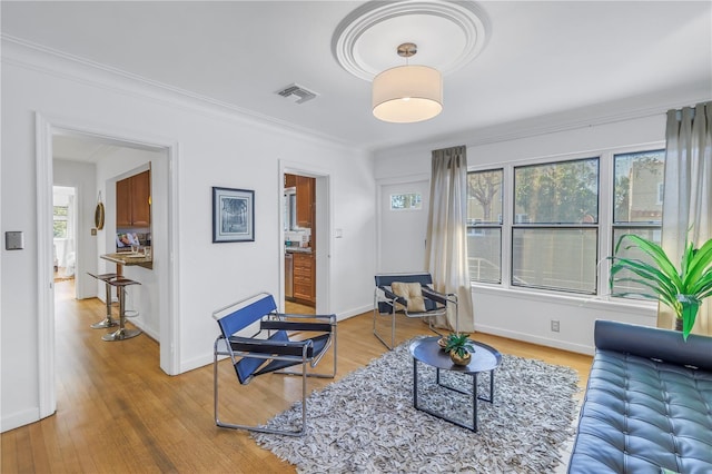 living room featuring hardwood / wood-style floors, a healthy amount of sunlight, and ornamental molding