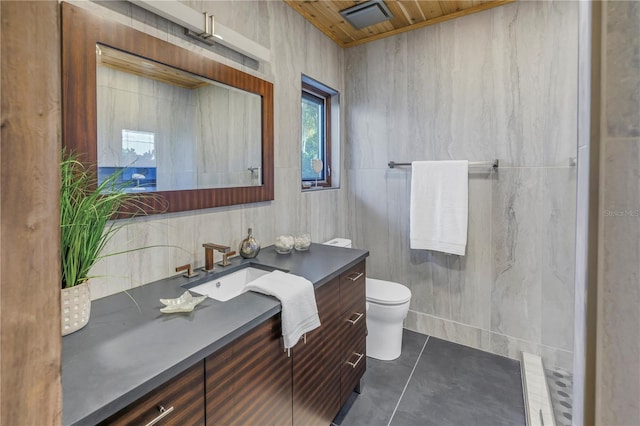 bathroom with tile patterned flooring, toilet, vanity, wood ceiling, and tile walls