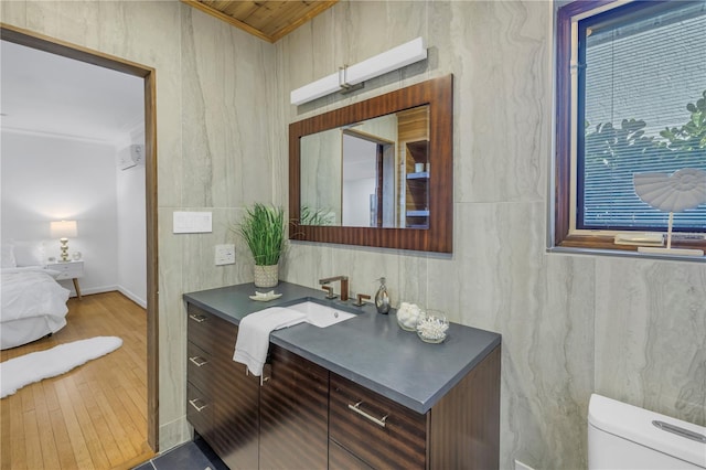 bathroom with hardwood / wood-style floors, vanity, toilet, and ornamental molding