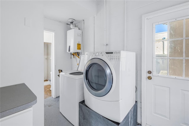 laundry room with tankless water heater and washer / dryer