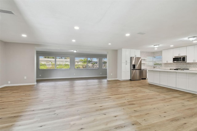 unfurnished living room with light hardwood / wood-style floors and plenty of natural light