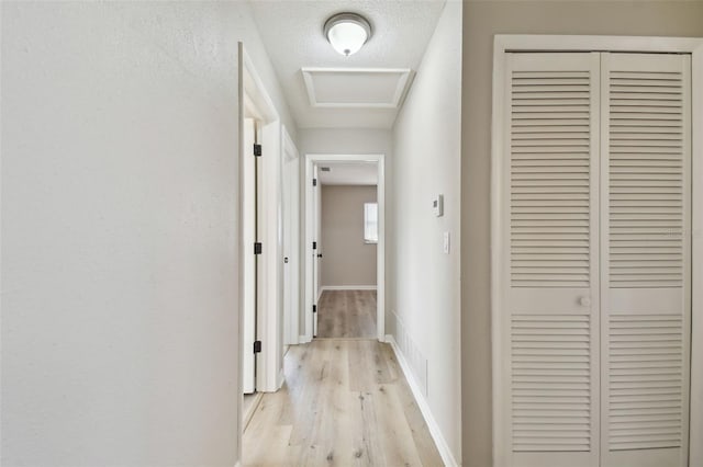 hallway featuring a textured ceiling and light wood-type flooring