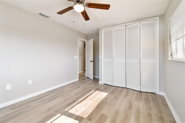 unfurnished bedroom featuring light wood-type flooring, a closet, and ceiling fan