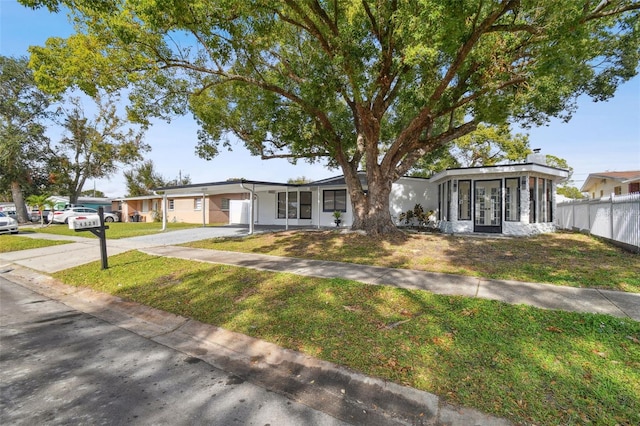 ranch-style house with a sunroom and a front lawn