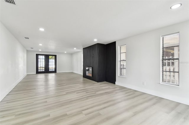 empty room featuring light wood-type flooring and french doors