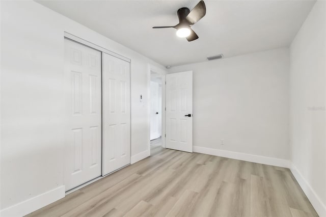 unfurnished bedroom featuring light hardwood / wood-style floors, a closet, and ceiling fan