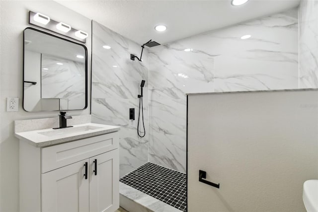 bathroom featuring a tile shower and vanity