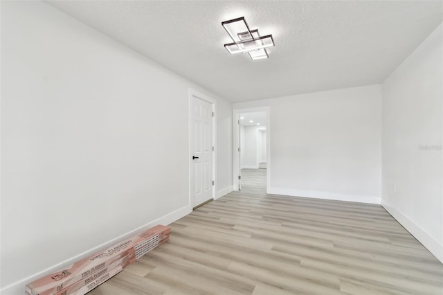 interior space featuring light wood-type flooring and a textured ceiling