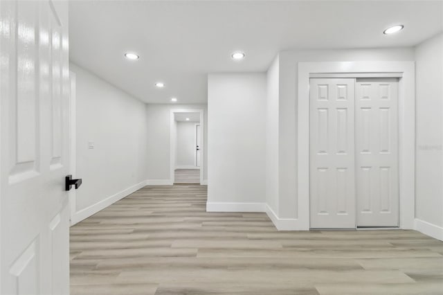 hallway with light hardwood / wood-style floors