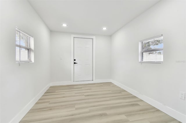 spare room featuring plenty of natural light and light hardwood / wood-style flooring