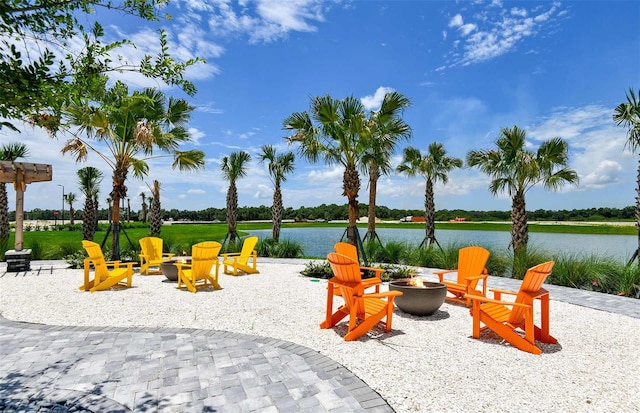 view of jungle gym with a water view, a patio, and an outdoor fire pit