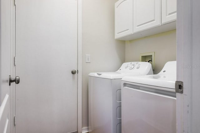 clothes washing area with washing machine and dryer and cabinets