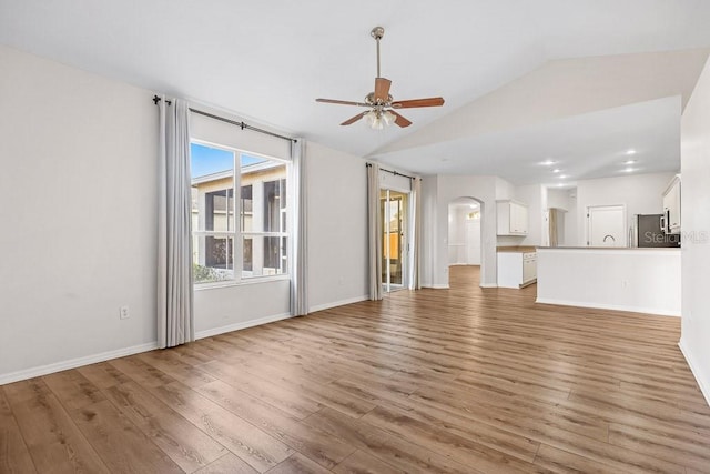 unfurnished living room with hardwood / wood-style flooring, a wealth of natural light, and lofted ceiling