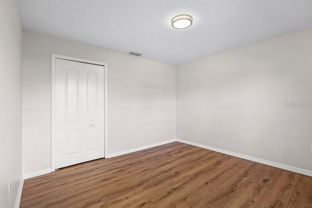 unfurnished bedroom featuring hardwood / wood-style floors and a closet