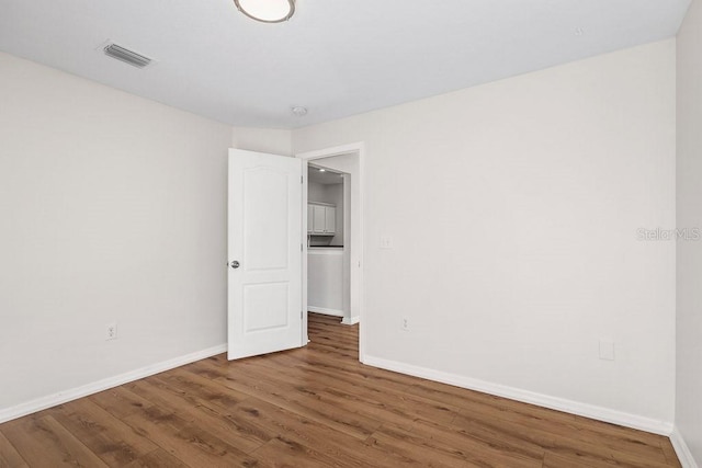 unfurnished room with dark hardwood / wood-style floors