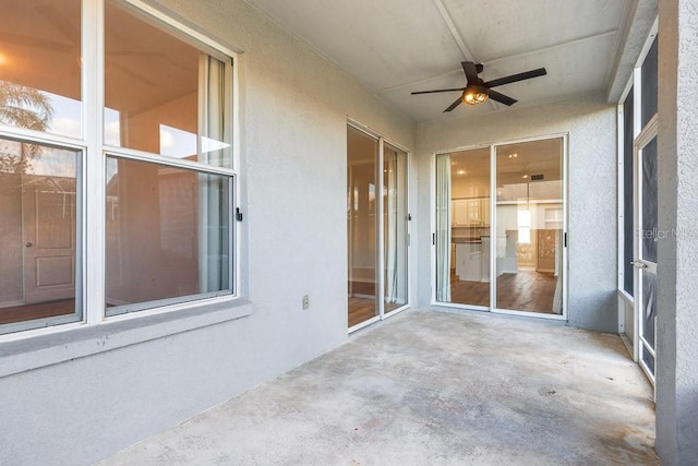 unfurnished sunroom featuring ceiling fan