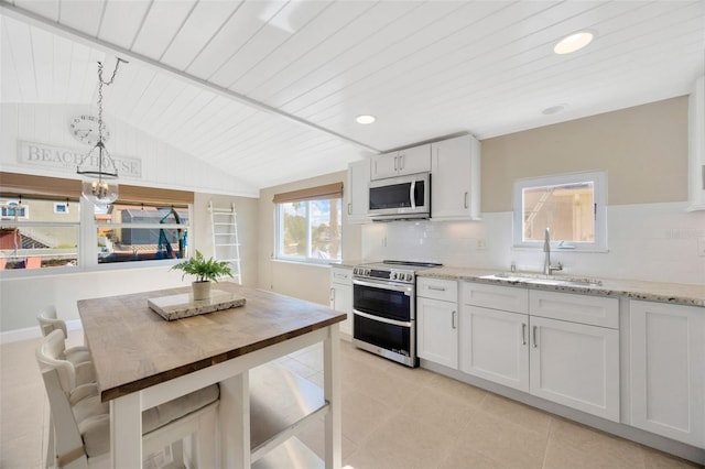 kitchen featuring sink, decorative light fixtures, light stone counters, white cabinetry, and stainless steel appliances