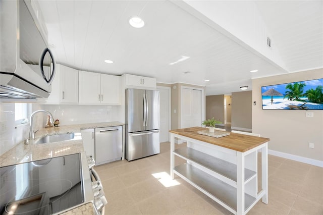 kitchen with white cabinetry, sink, stainless steel appliances, tasteful backsplash, and light stone counters