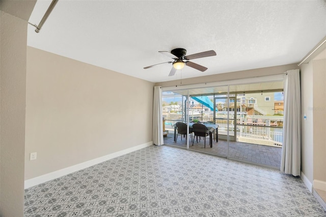 interior space with ceiling fan and a textured ceiling