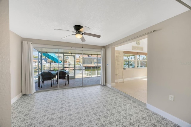 spare room featuring a wealth of natural light, ceiling fan, and a textured ceiling