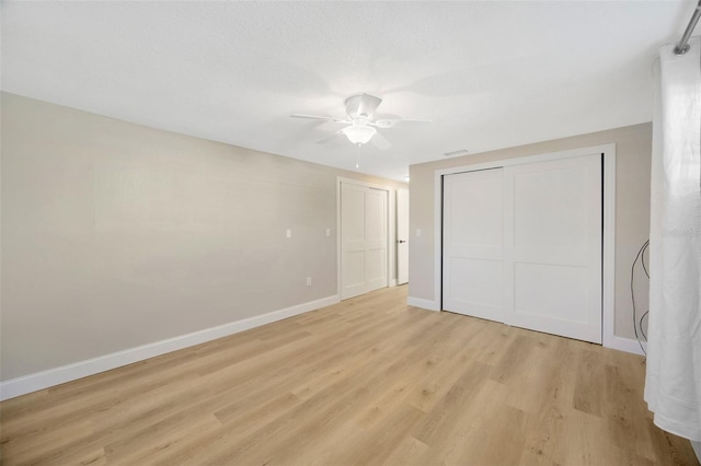 unfurnished bedroom with a closet, light hardwood / wood-style flooring, and ceiling fan