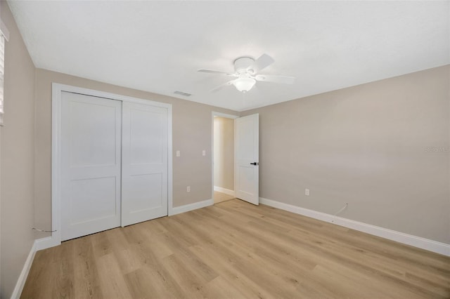 unfurnished bedroom featuring ceiling fan, a closet, and light hardwood / wood-style floors