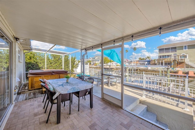 sunroom featuring a water view