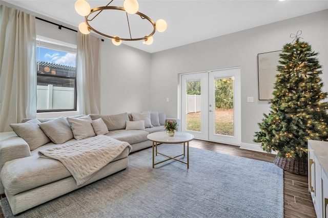 living room featuring wood-type flooring, french doors, and an inviting chandelier