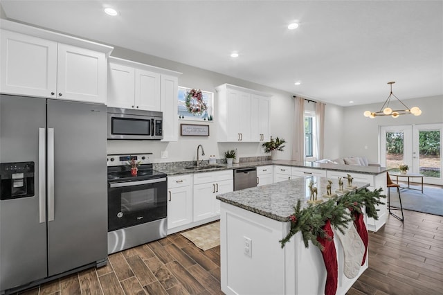 kitchen with kitchen peninsula, white cabinetry, sink, and appliances with stainless steel finishes