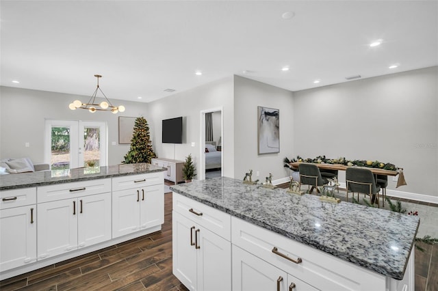 kitchen with white cabinets, pendant lighting, dark hardwood / wood-style floors, and stone counters