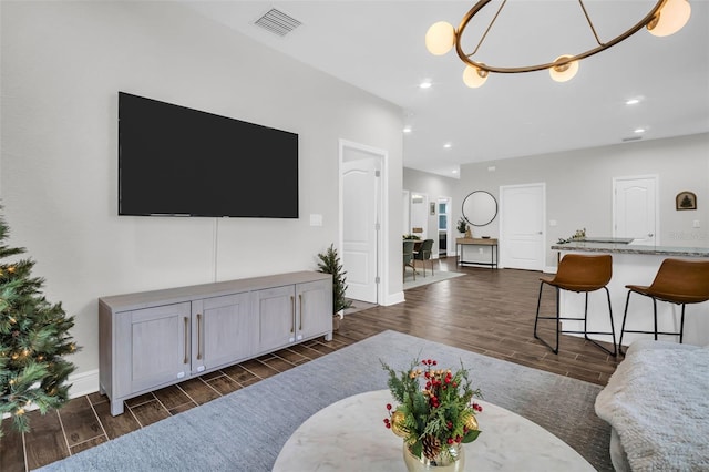 living room featuring a chandelier and dark wood-type flooring