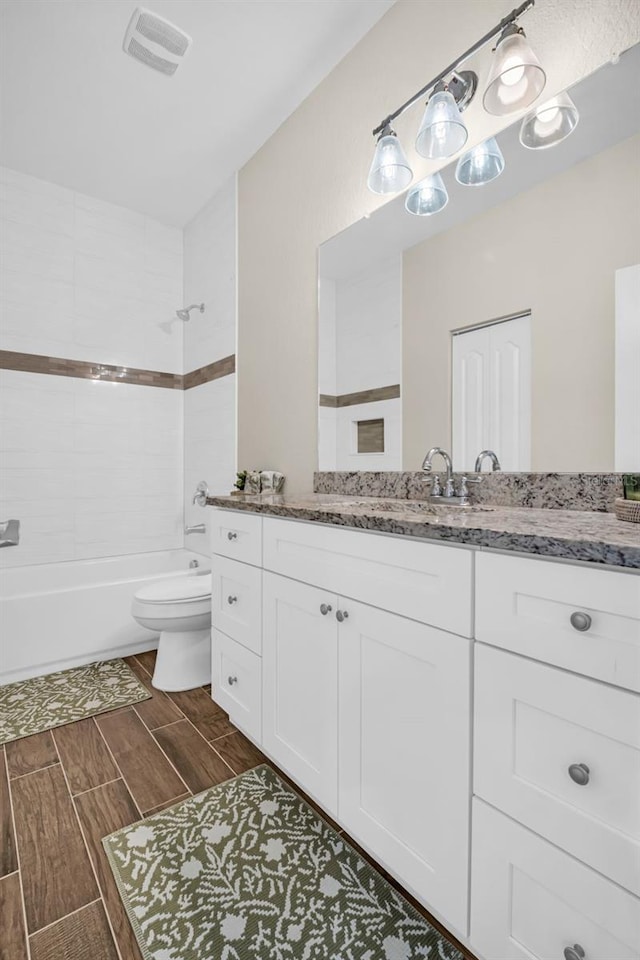 full bathroom featuring toilet, vanity, and tiled shower / bath combo