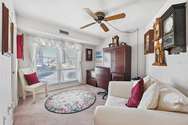 living area with light carpet, a textured ceiling, and ceiling fan