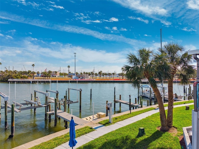 dock area with a lawn and a water view