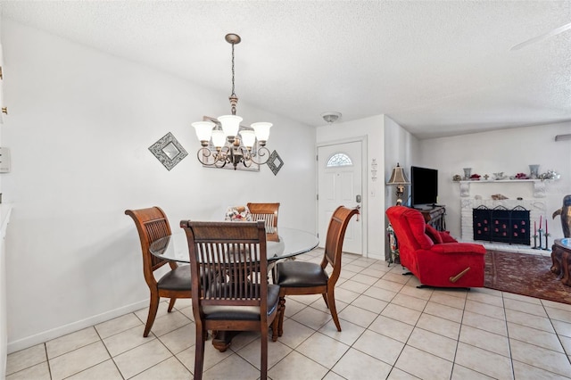 dining space featuring light tile patterned floors, a textured ceiling, and an inviting chandelier