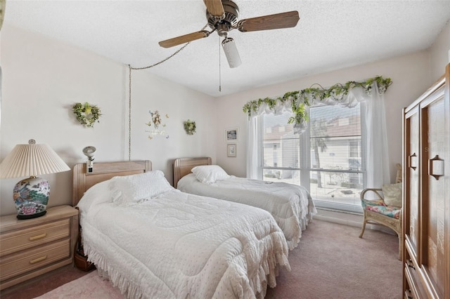 bedroom featuring carpet flooring, ceiling fan, and a textured ceiling