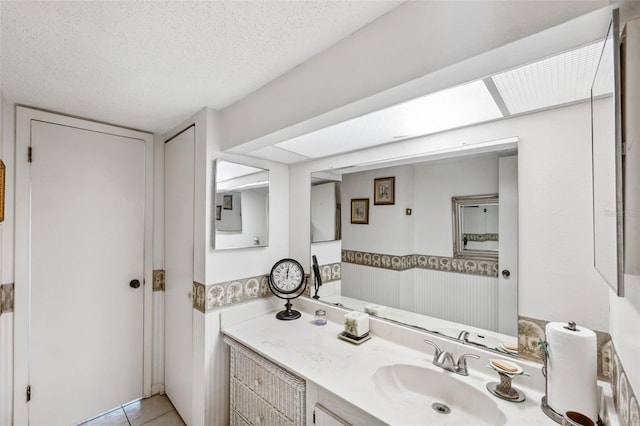 bathroom with tile patterned floors, vanity, and a textured ceiling