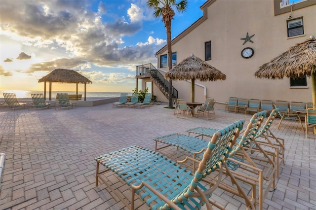 patio terrace at dusk with a gazebo and a water view