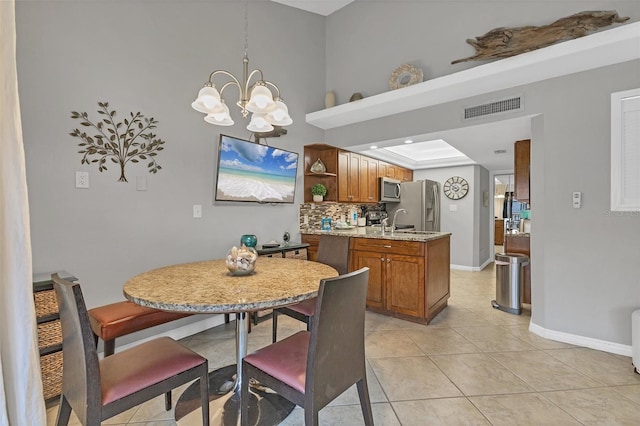 tiled dining space with an inviting chandelier and sink