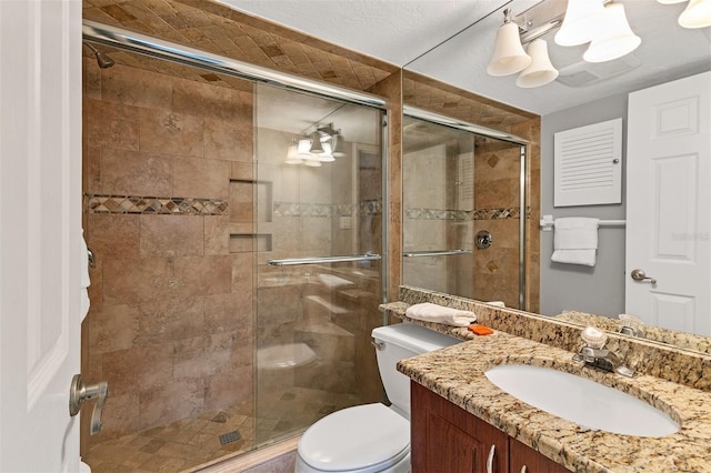 bathroom with a shower with door, vanity, and toilet