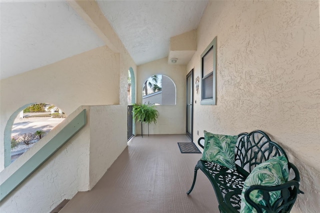 corridor with hardwood / wood-style floors and vaulted ceiling with beams
