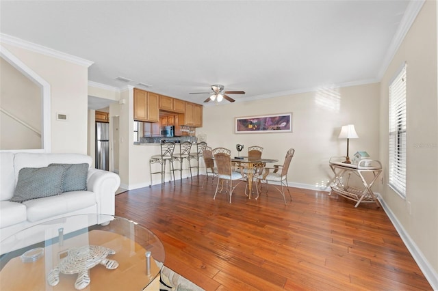 living room featuring hardwood / wood-style flooring, ceiling fan, and ornamental molding