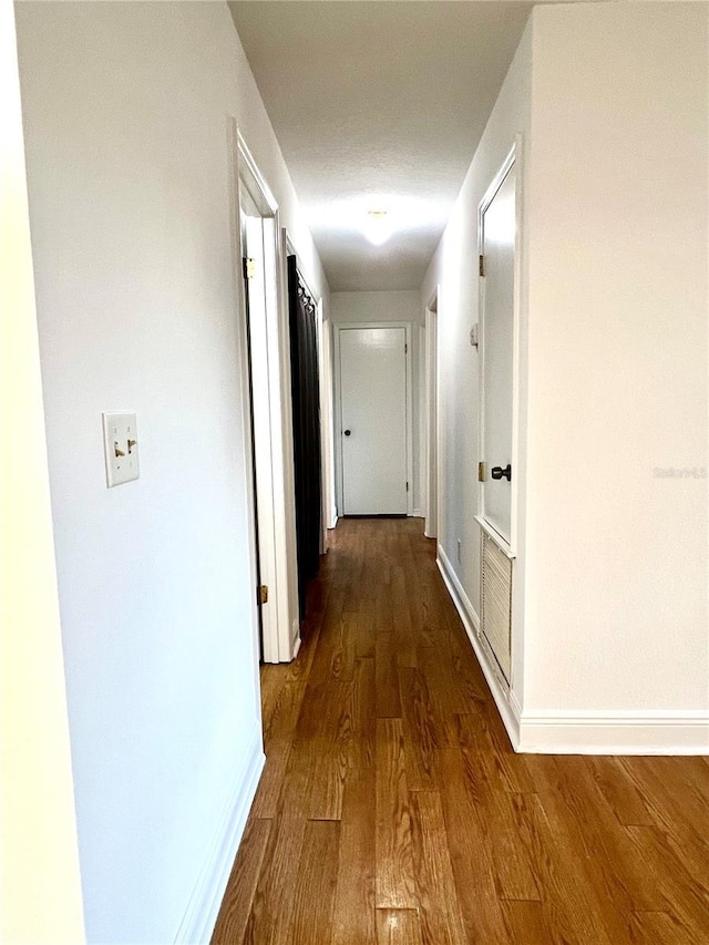 corridor with dark hardwood / wood-style floors