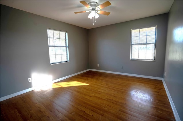 empty room featuring wood-type flooring, ceiling fan, and a healthy amount of sunlight