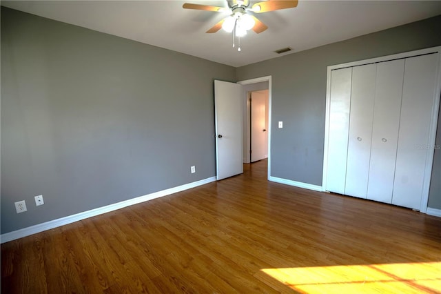 unfurnished bedroom with wood-type flooring, a closet, and ceiling fan