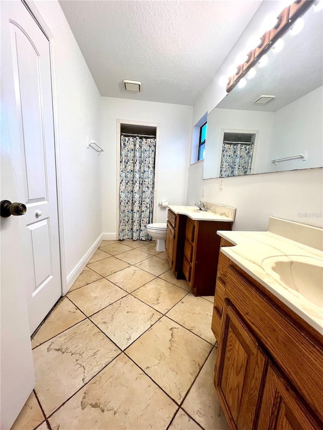 bathroom featuring vanity, a textured ceiling, and toilet