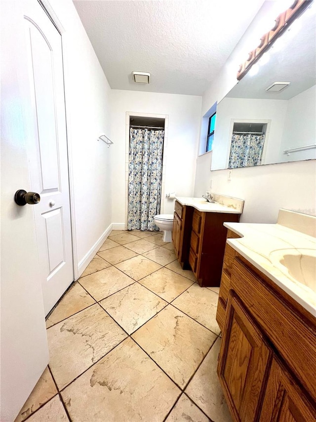 bathroom with vanity, a textured ceiling, and toilet