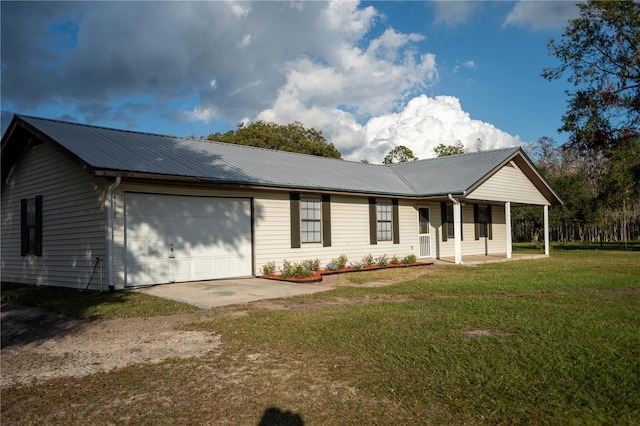 view of front of house with covered porch, a garage, and a front lawn