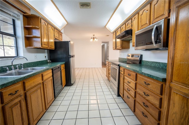 kitchen featuring a textured ceiling, light tile patterned flooring, sink, and appliances with stainless steel finishes