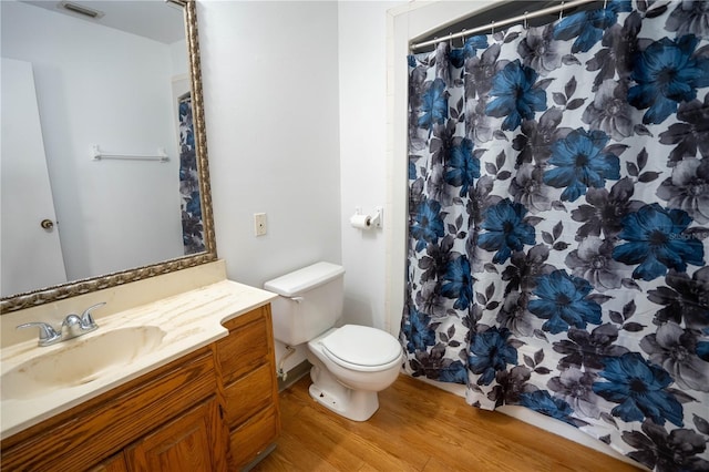 bathroom featuring a shower with shower curtain, vanity, toilet, and wood-type flooring